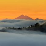 Kabut tebal, pemandangan gunung, plus langit oranye bikin suasana makin dramatis. Photo by Koes nadi.