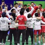 Tim bulu tangkis Indonesia selebrasi bersama di sisi net dengan jaket Indonesia