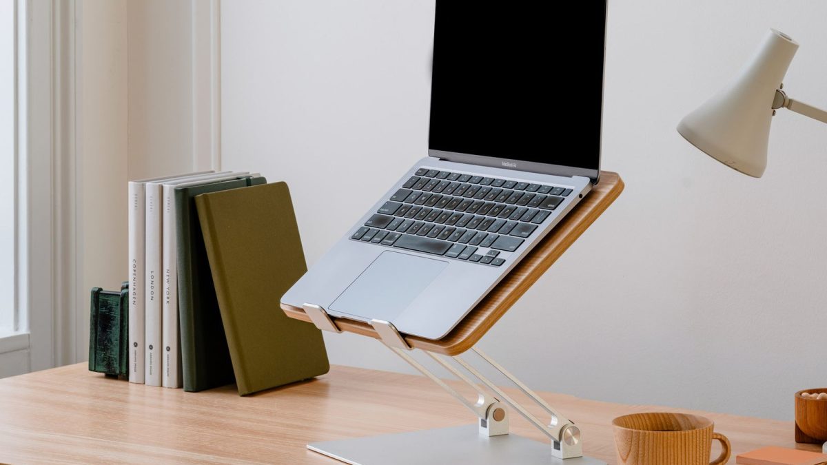 Laptop di dudukan kayu di atas meja belajar
