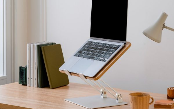 Laptop di dudukan kayu di atas meja belajar