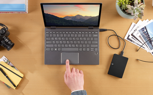 Laptop dan hard disk eksternal di atas meja kerja