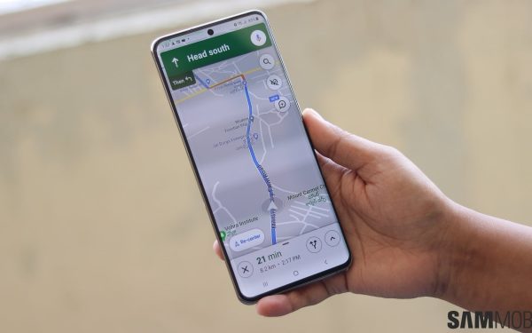 Tangan memegang ponsel dengan aplikasi peta