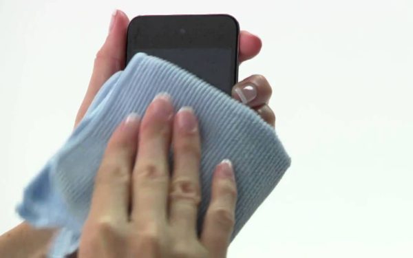 Membersihkan layar ponsel dengan kain microfiber