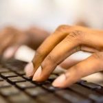 Tangan mengetik di papan ketik laptop