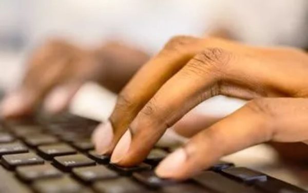 Tangan mengetik di papan ketik laptop