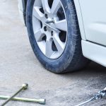 Mobil terdongkrak dengan kunci roda bersiap di tanah