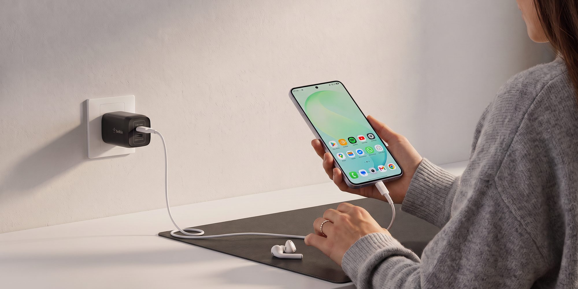 Tangan menyambungkan kabel charger ke colokan dinding