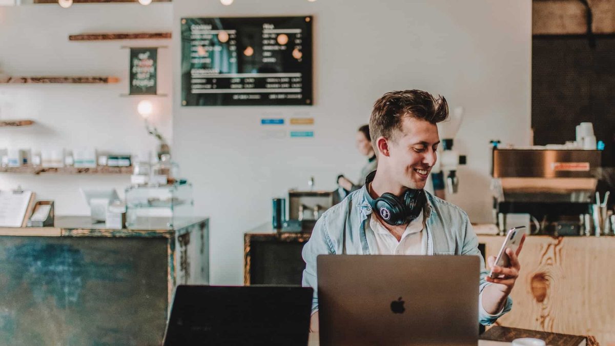 Seseorang bekerja dengan laptop di kafe