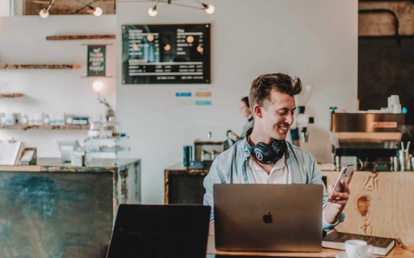 Seseorang bekerja dengan laptop di kafe