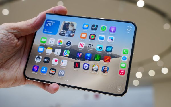 Tangan memegang tablet dengan deretan aplikasi