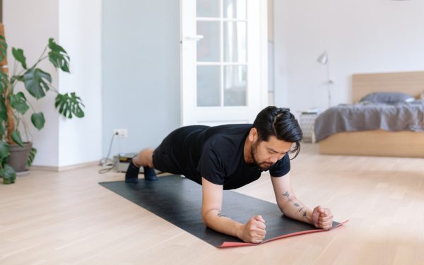 Seseorang berlatih push-up di lantai kayu