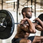 Seseorang berlatih squat barbel di gym