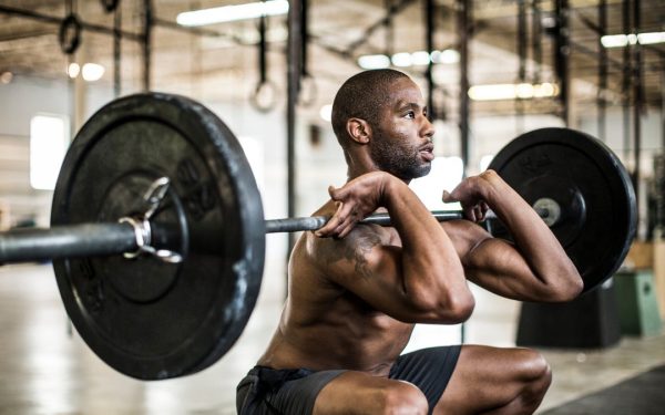 Seseorang berlatih squat barbel di gym