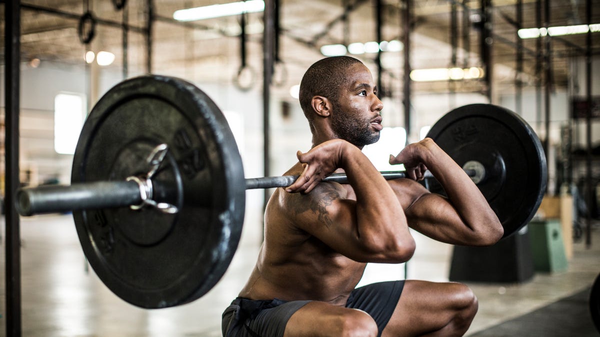 Seseorang berlatih squat barbel di gym
