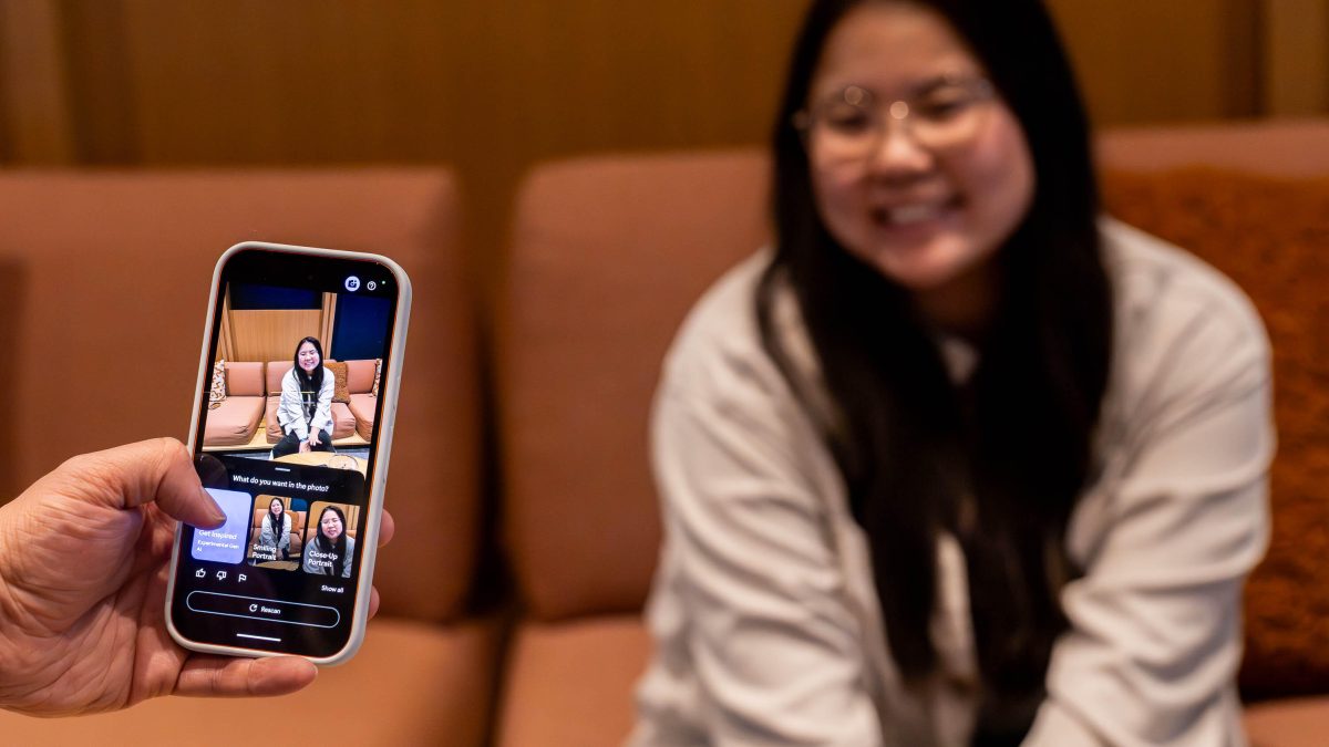 Tangan memegang ponsel dengan menu opsi fitur kamera terbuka di layar