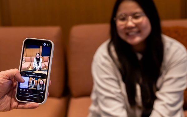 Tangan memegang ponsel dengan menu opsi fitur kamera terbuka di layar