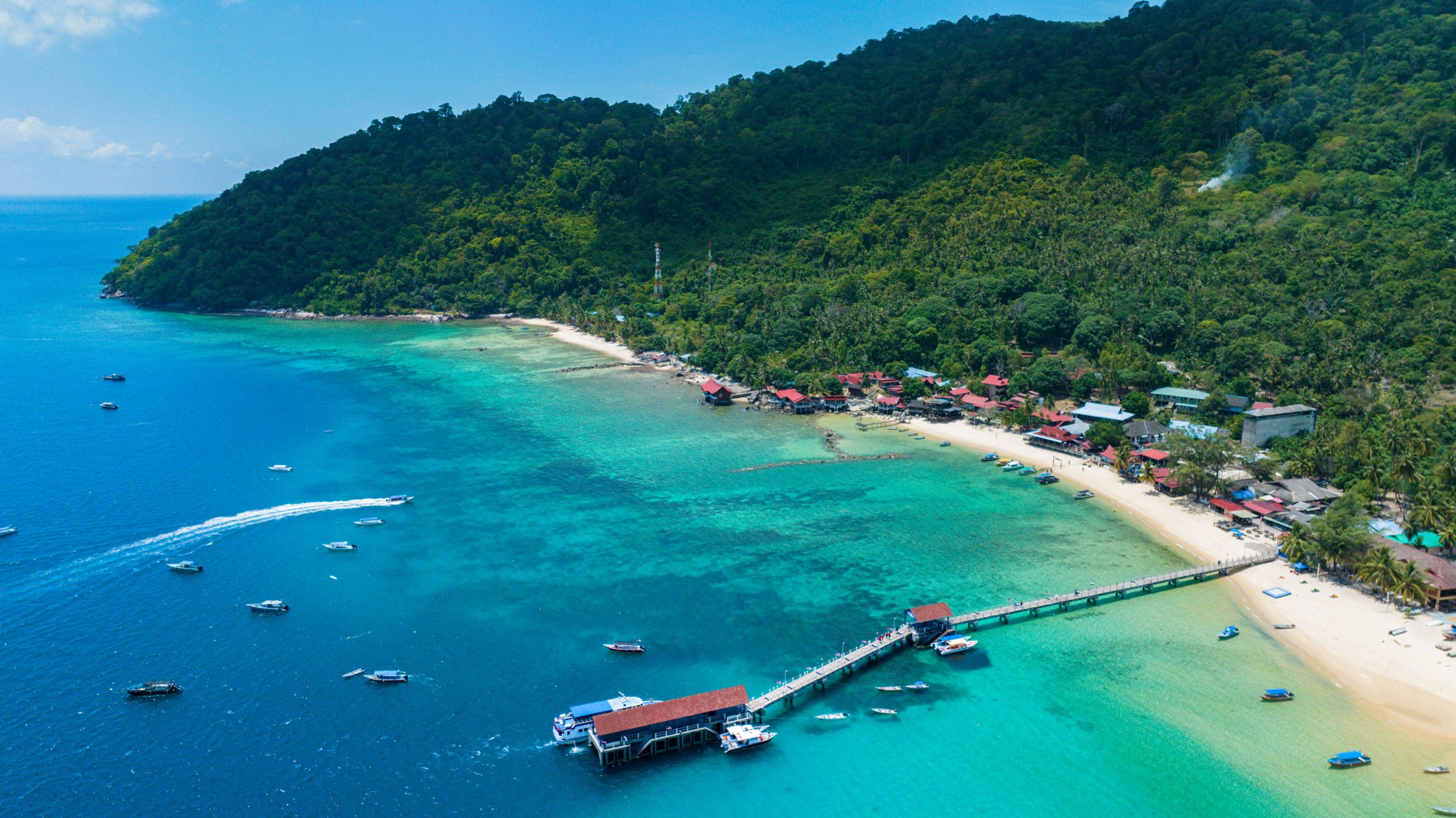 Perairan tropis jernih dengan perahu tradisional di atas karang dangkal