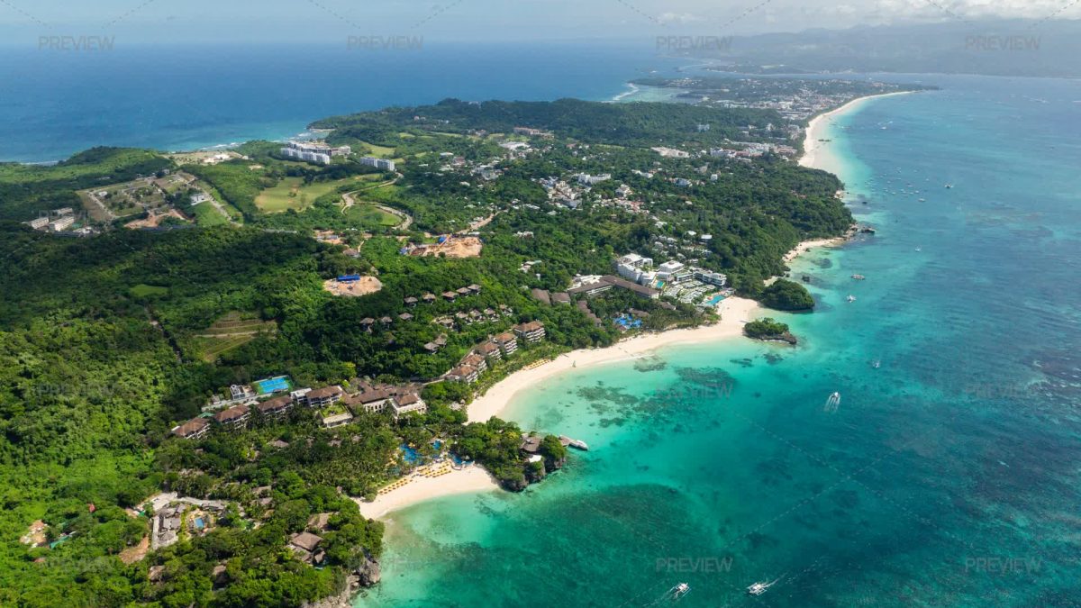 Pemandangan udara garis pantai pulau tropis dengan laut biru kehijauan dan hutan rimbun