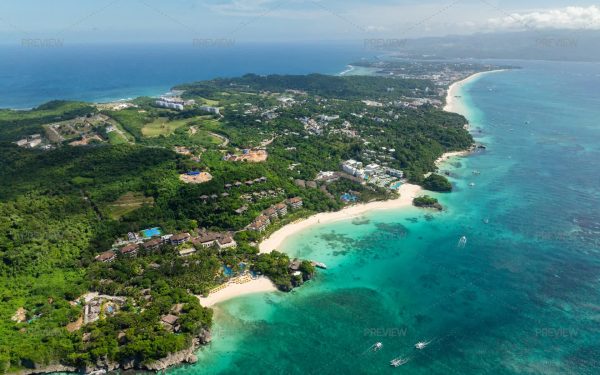 Pemandangan udara garis pantai pulau tropis dengan laut biru kehijauan dan hutan rimbun