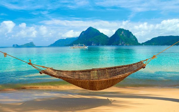 Pantai tropis dengan ayunan gantung untuk liburan hemat