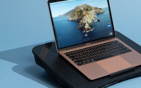Laptop diletakkan di atas bantalan sofa
