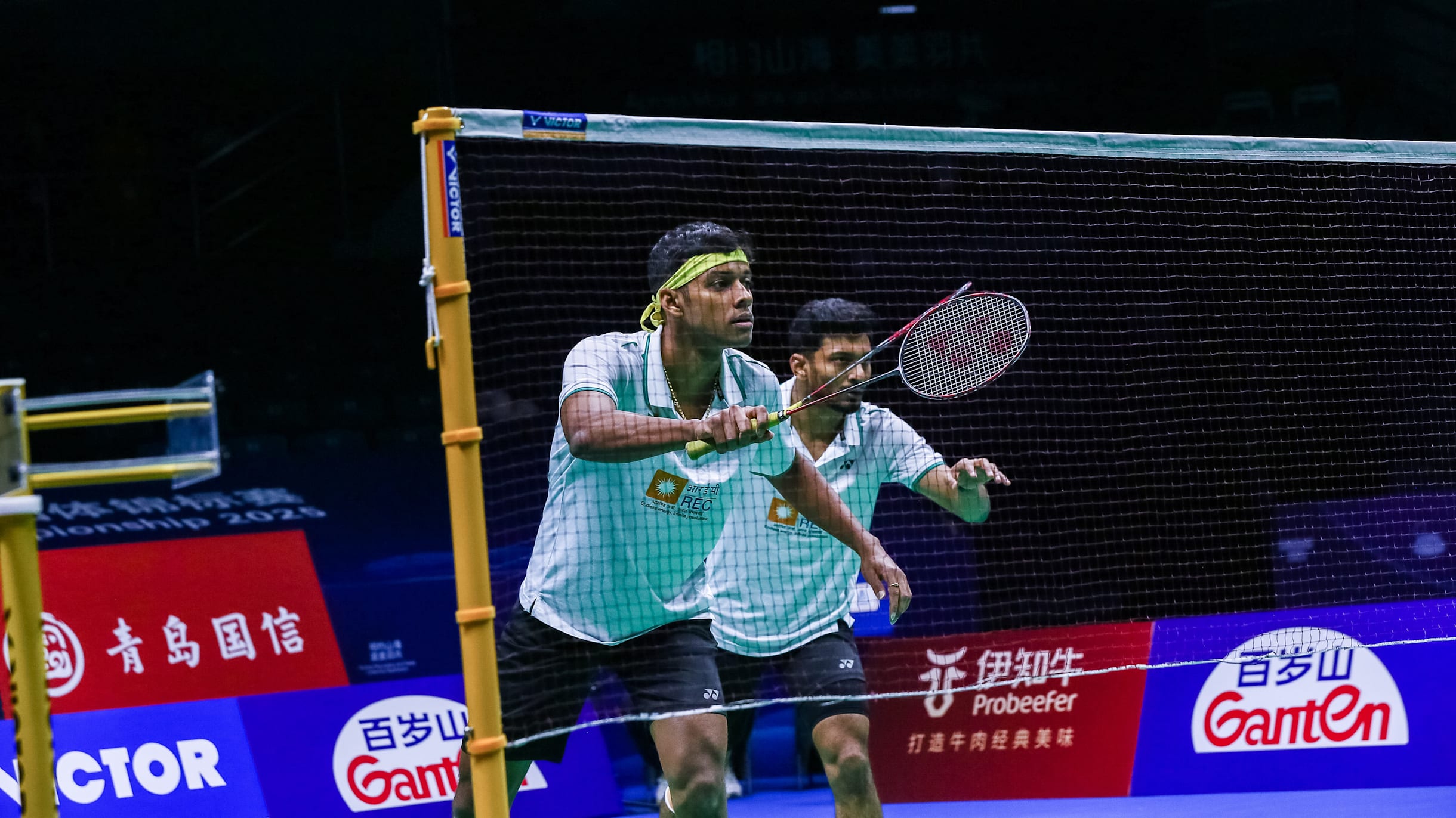 Pasangan ganda bulu tangkis bersiap di jaring pada turnamen profesional