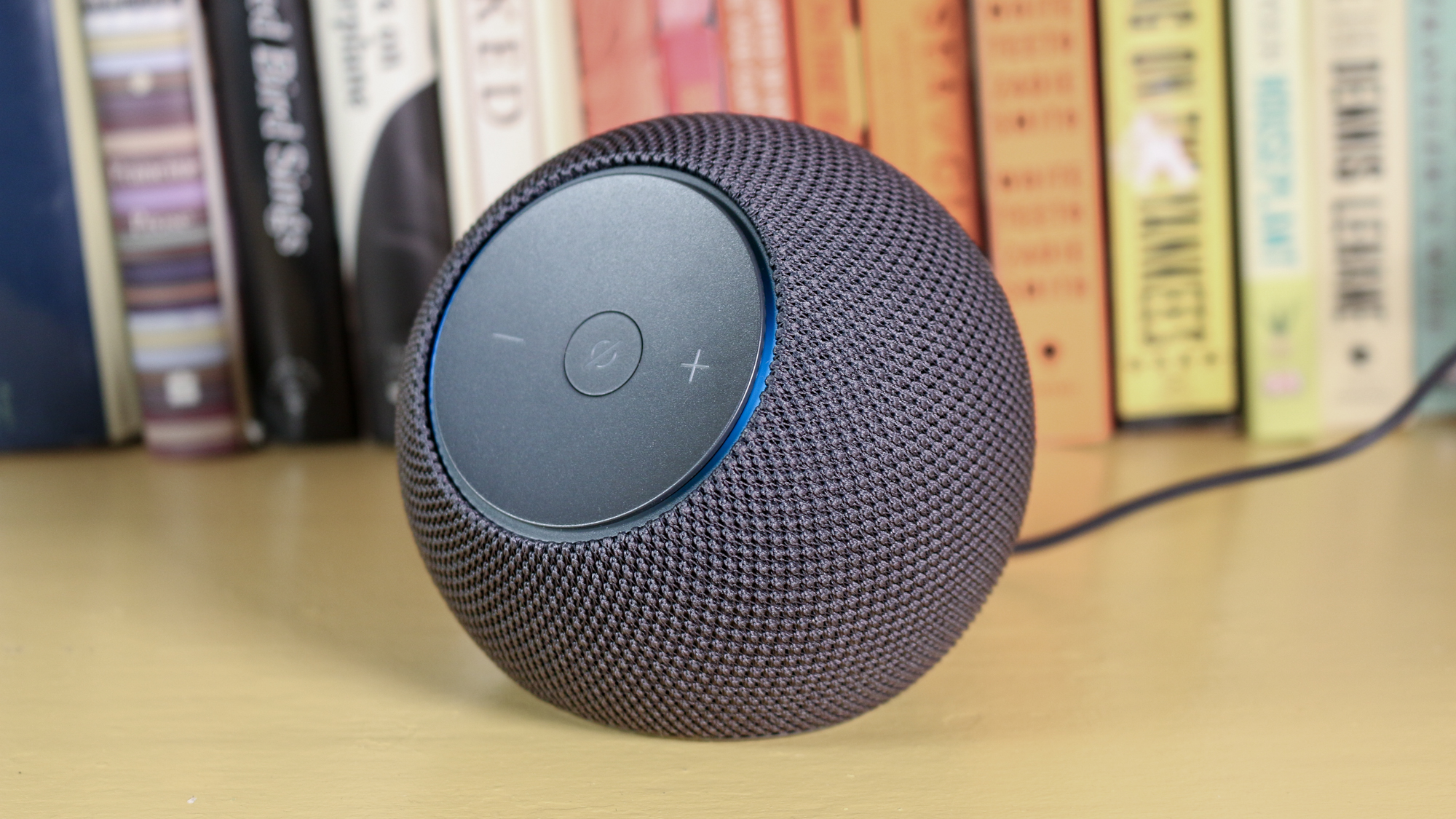 Speaker pintar abu di samping rak buku