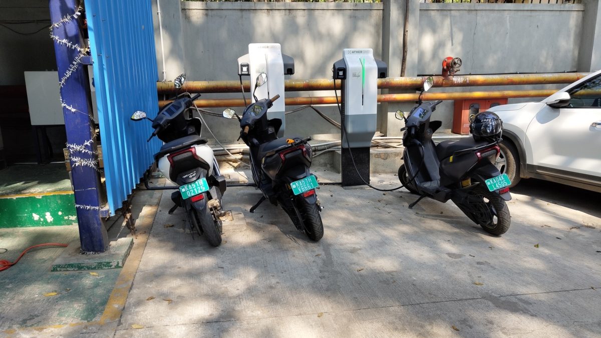 Tiga motor listrik terparkir mengisi daya di stasiun pengisian luar ruangan