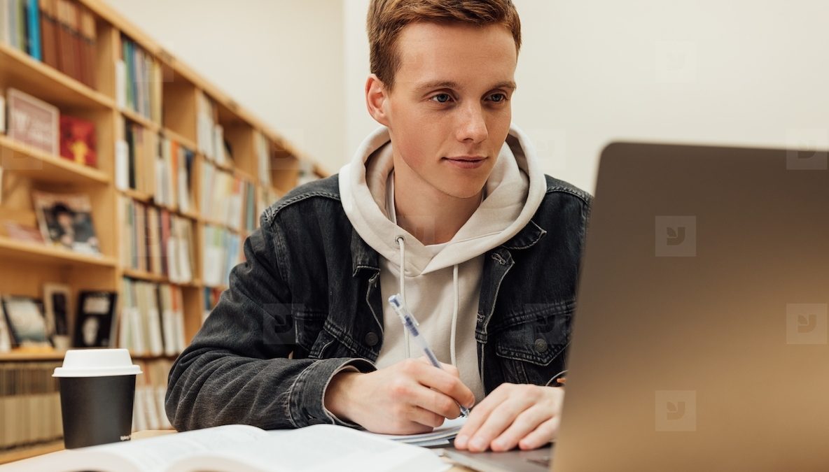 Mahasiswa bekerja dengan laptop di perpustakaan
