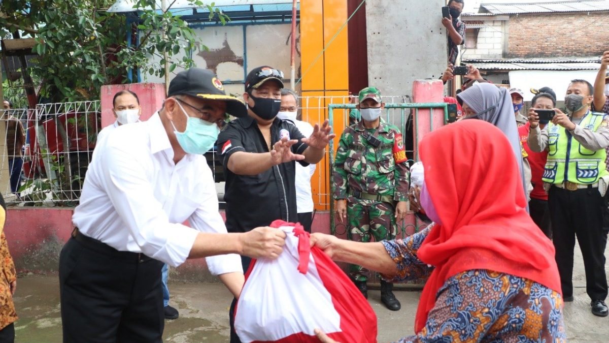 Pejabat menyerahkan paket bantuan sosial kepada penerima