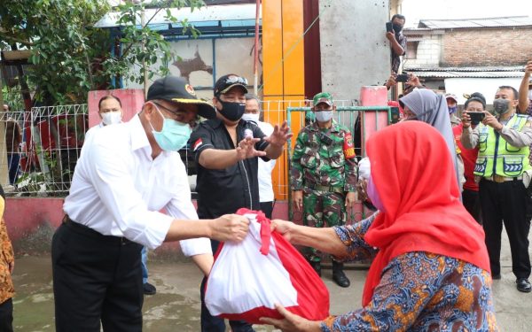 Pejabat menyerahkan paket bantuan sosial kepada penerima