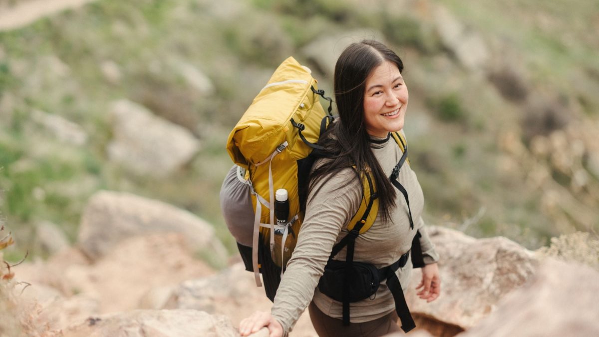 Pendaki dengan ransel kuning di jalur pendakian