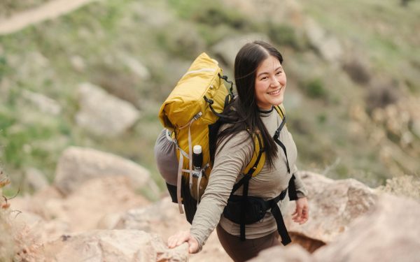 Pendaki dengan ransel kuning di jalur pendakian