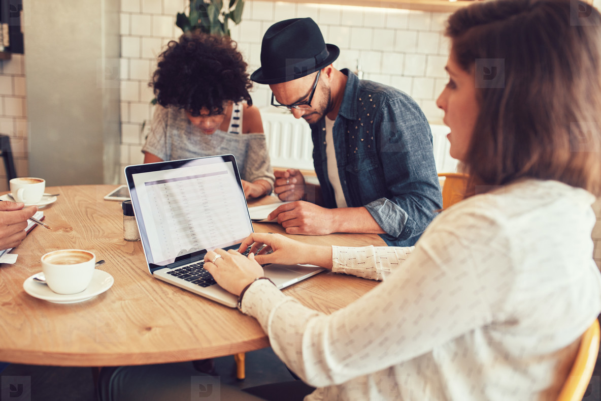 Beberapa orang bekerja bersama dengan laptop di kafe
