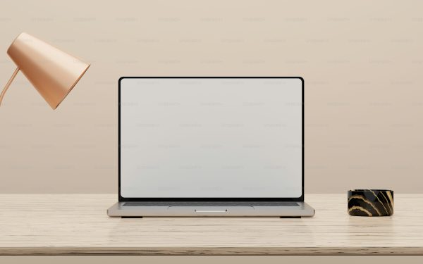 Laptop modern layar kosong di meja kayu bersama lampu tembaga dan cangkir