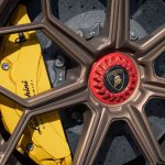 Cakram rem dengan kaliper kuning pada roda mobil