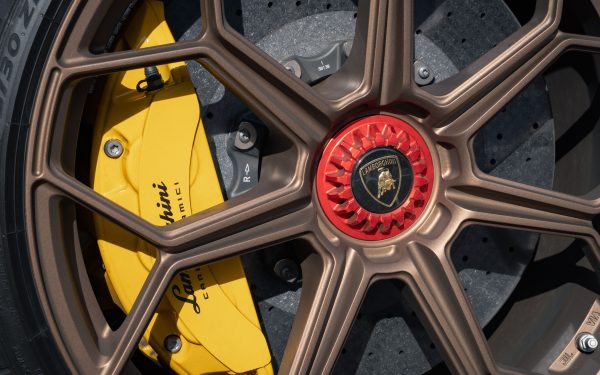 Cakram rem dengan kaliper kuning pada roda mobil