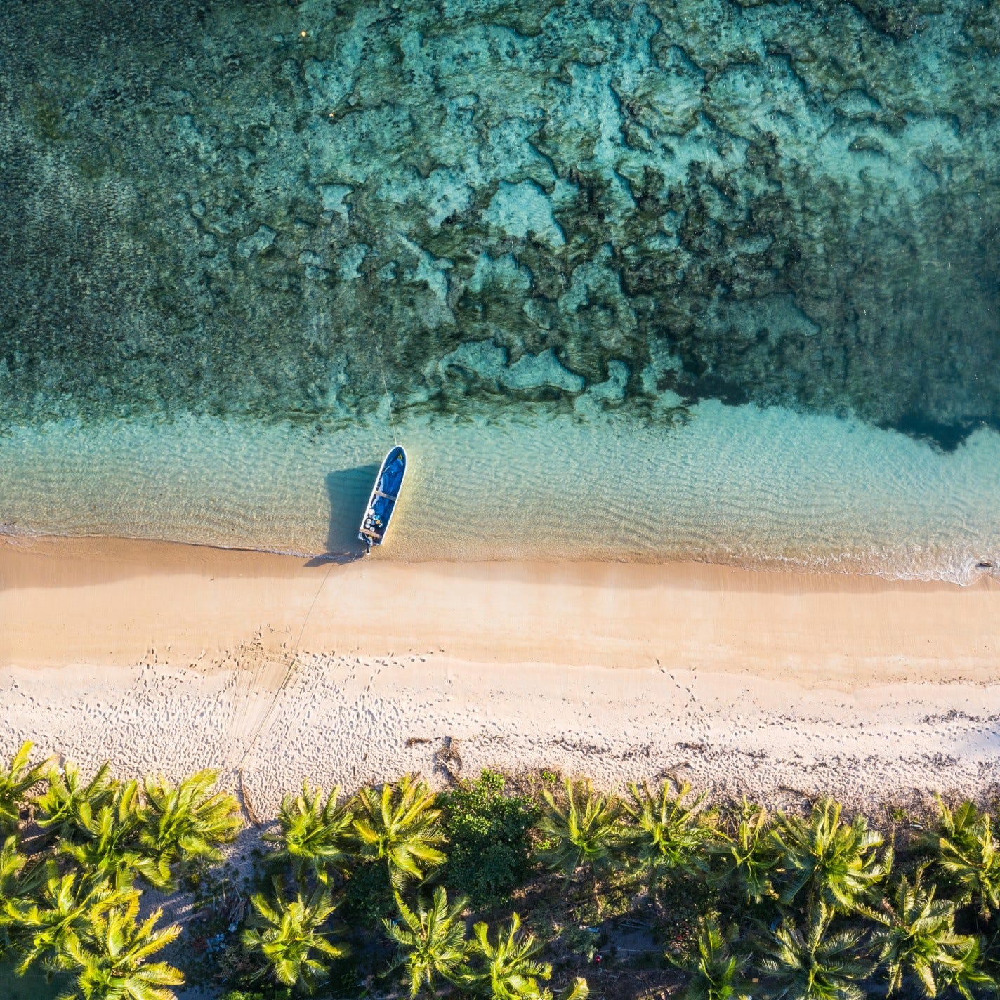 Pemandangan atas pantai tropis dengan perahu kecil dan air laut jernih
