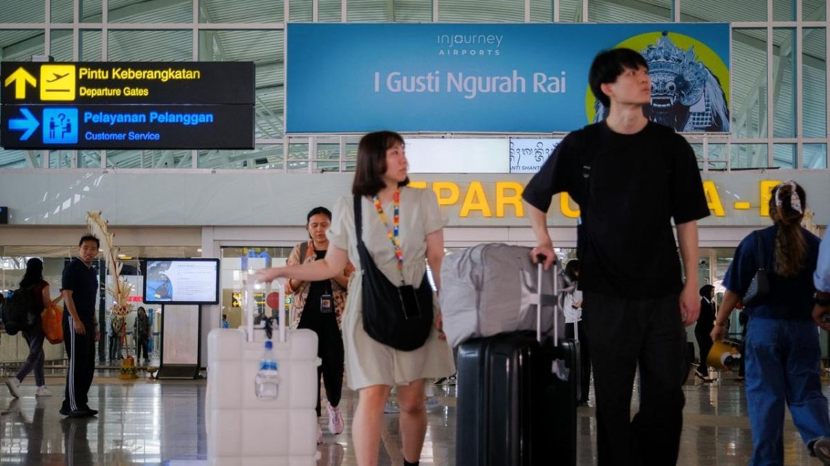 Perjalanan wisatawan berdesakan membawa koper di terminal Bandara I Gusti Ngurah Rai