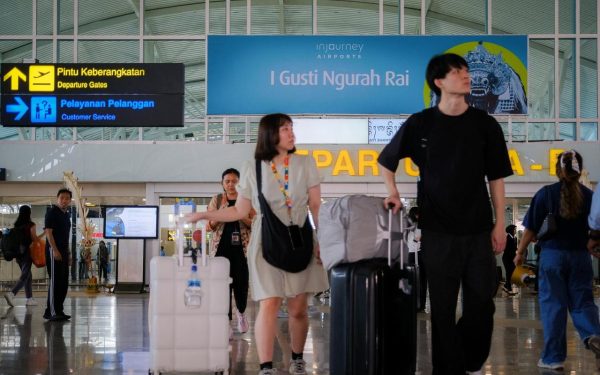 Perjalanan wisatawan berdesakan membawa koper di terminal Bandara I Gusti Ngurah Rai