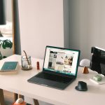 Laptop modern terbuka di atas meja kerja minimalis